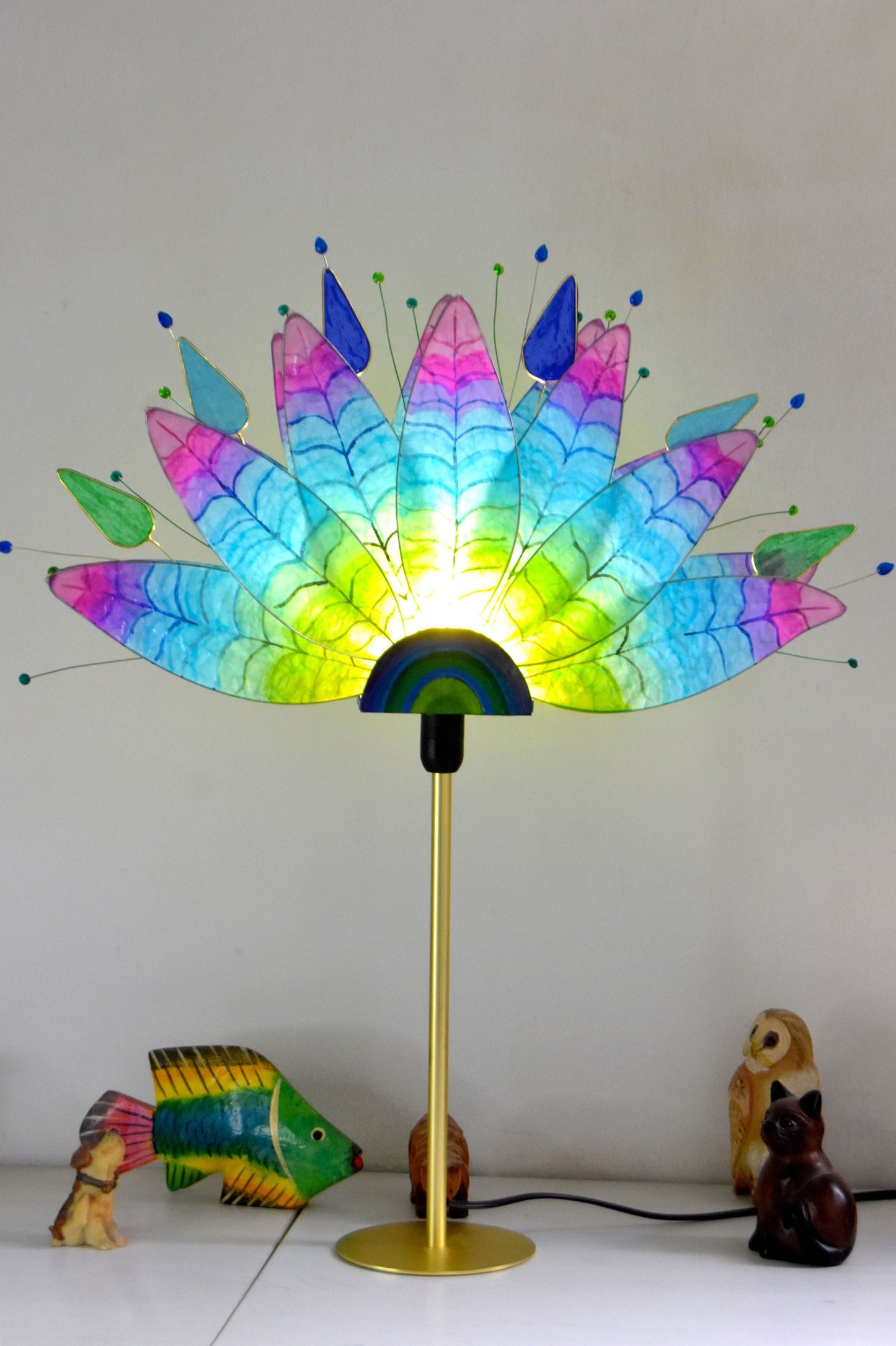 Lampada da tavolo fatta a mano con piume di pavone colorate su stelo dorato