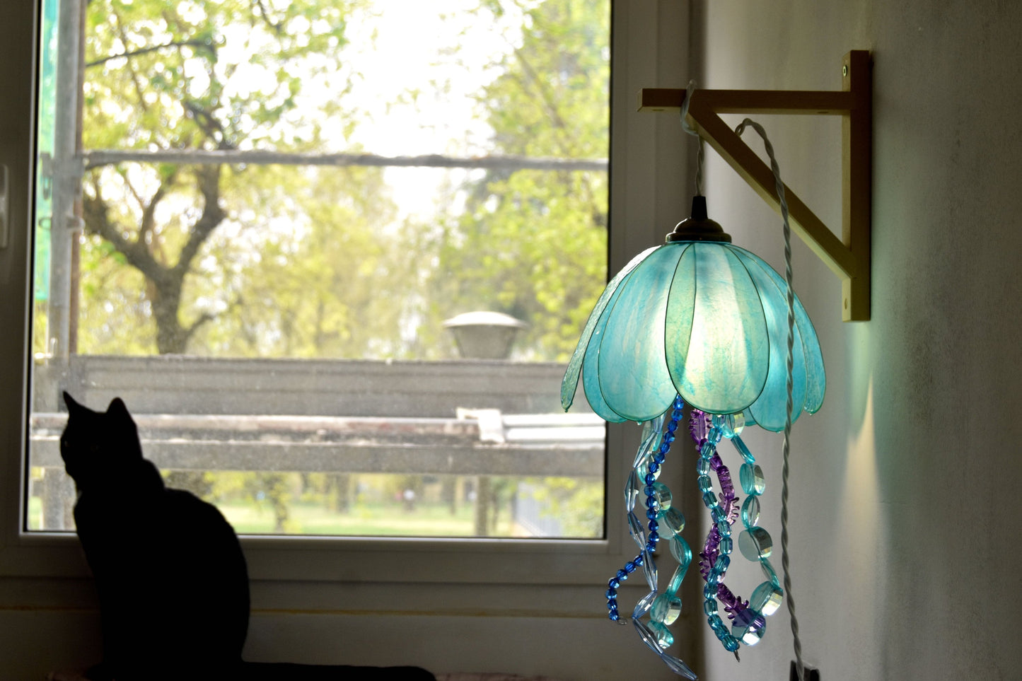 lampada a forma di medusa in resina da appendere alla parete, dipinta a mano