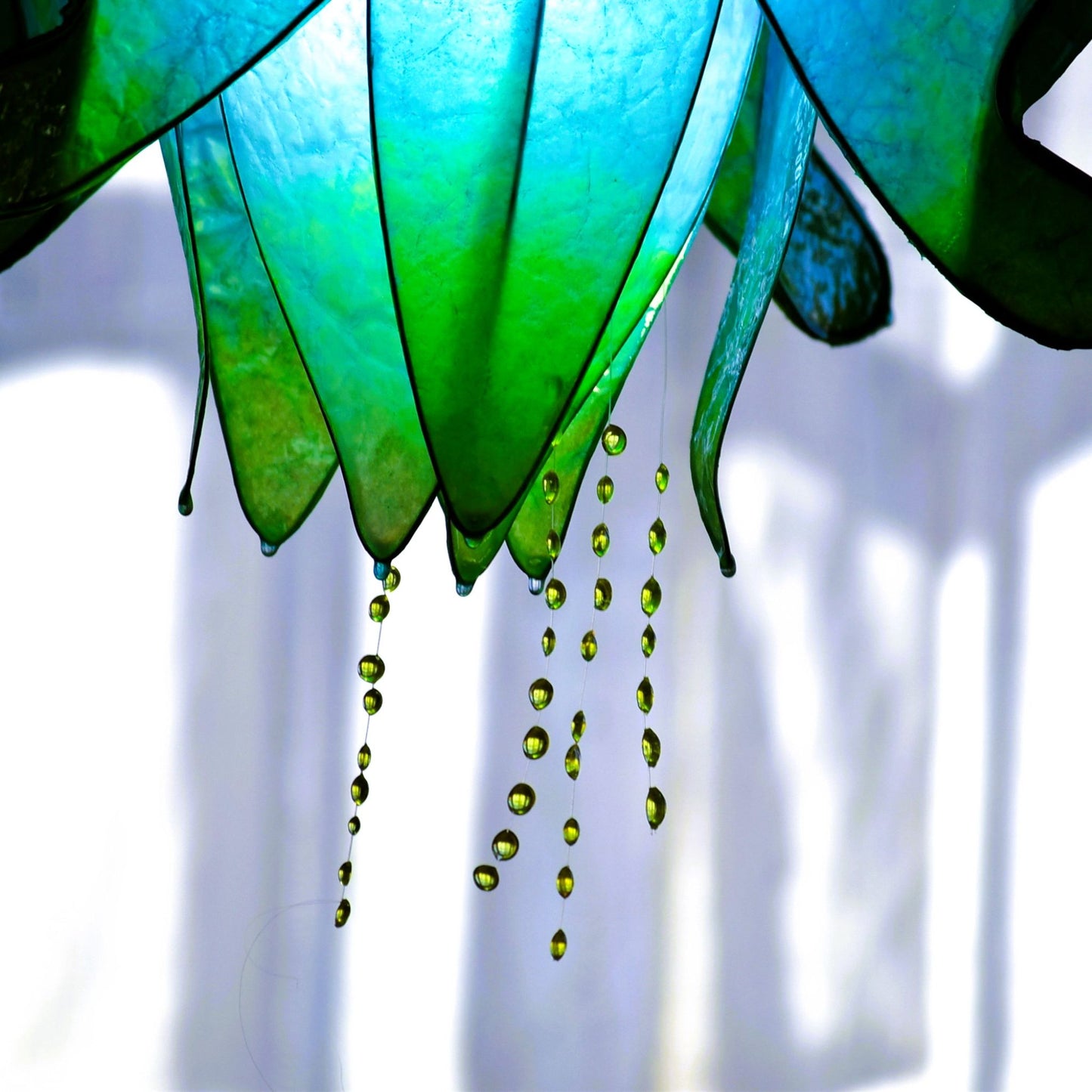 Particolare di lampada sospensione blu in resina con pistilli gialli