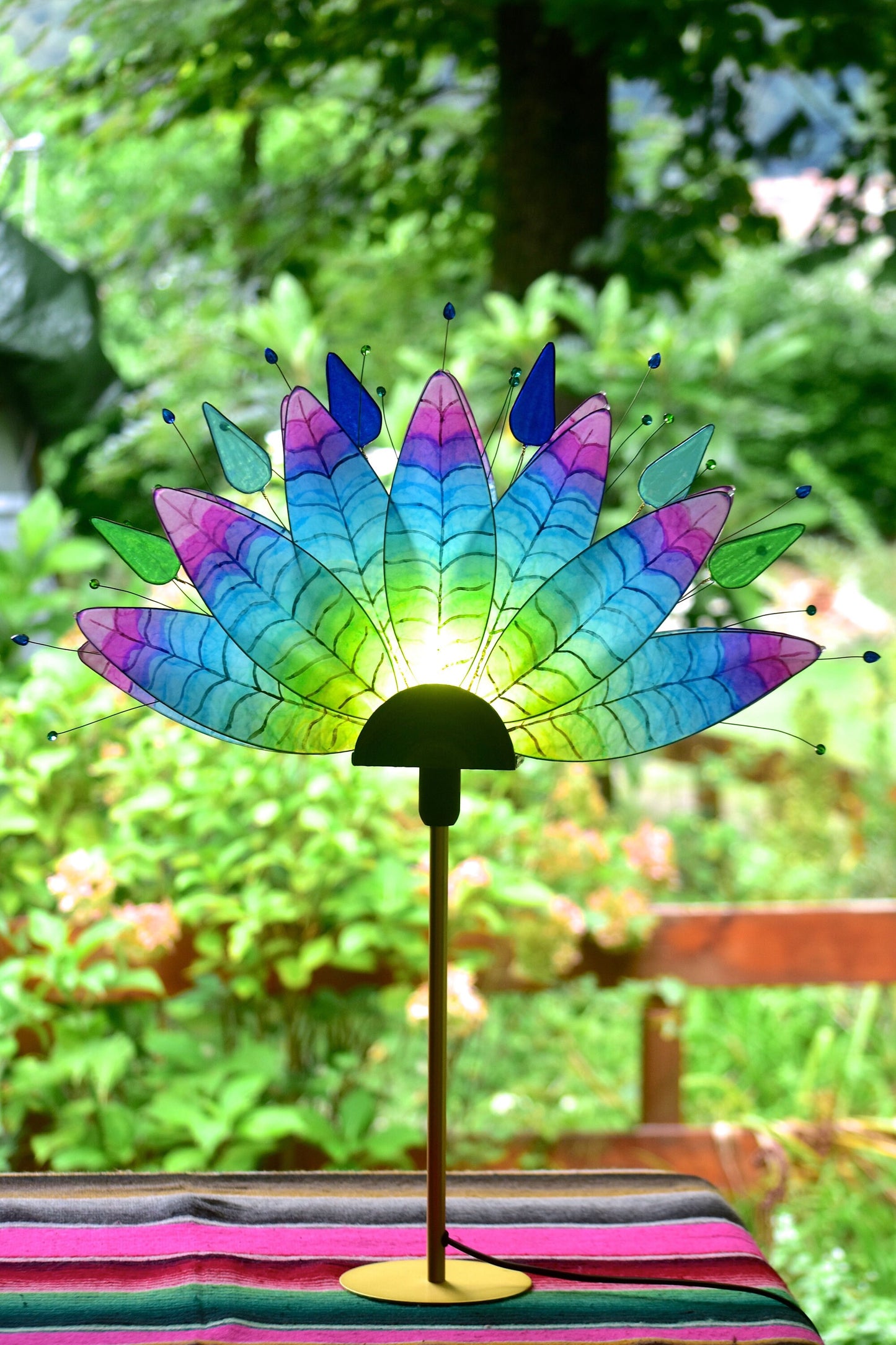 Lampada da tavolo fatta a mano con piume di pavone colorate su stelo dorato