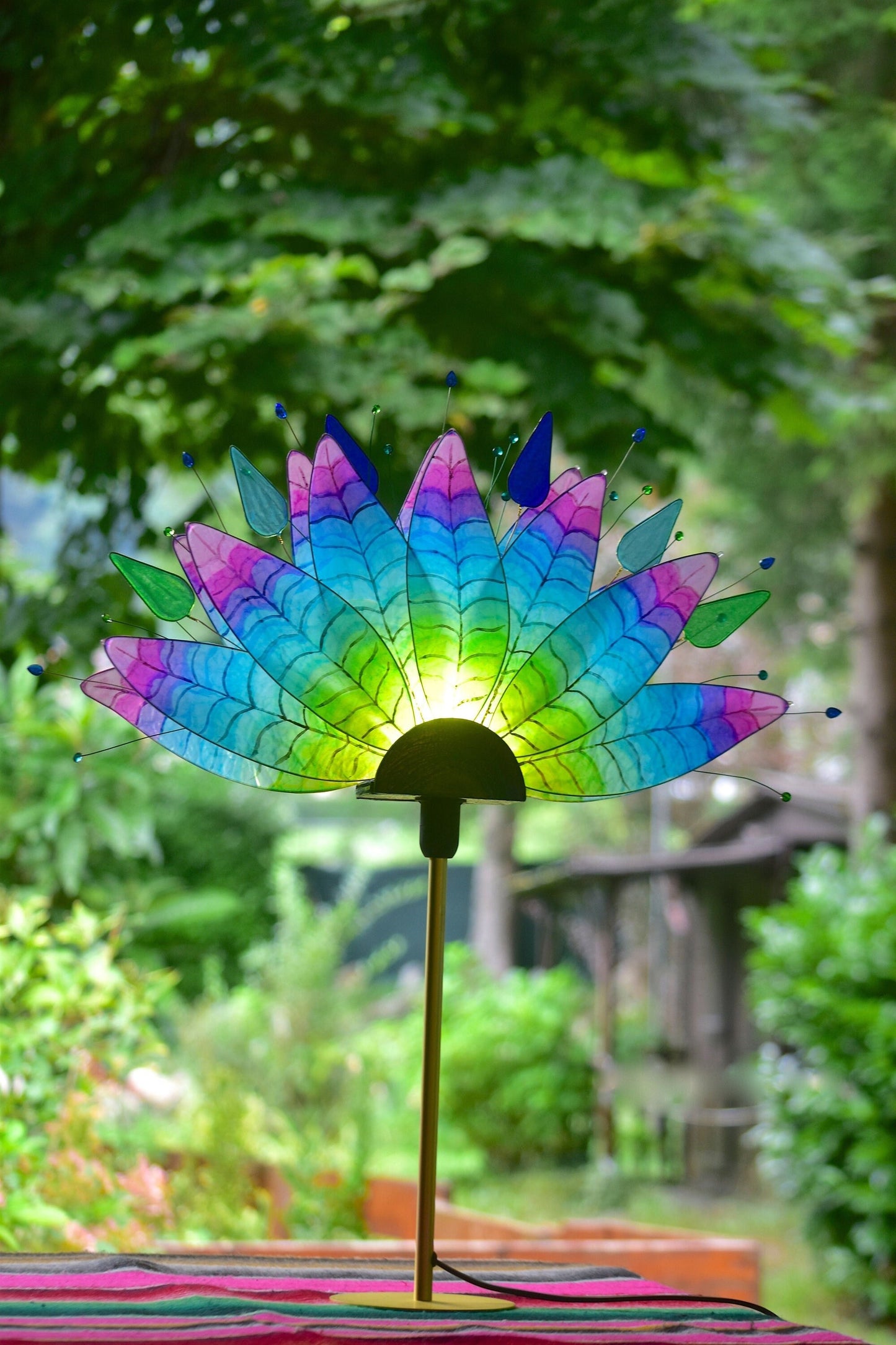 Lampada da tavolo fatta a mano con piume di pavone colorate su stelo dorato