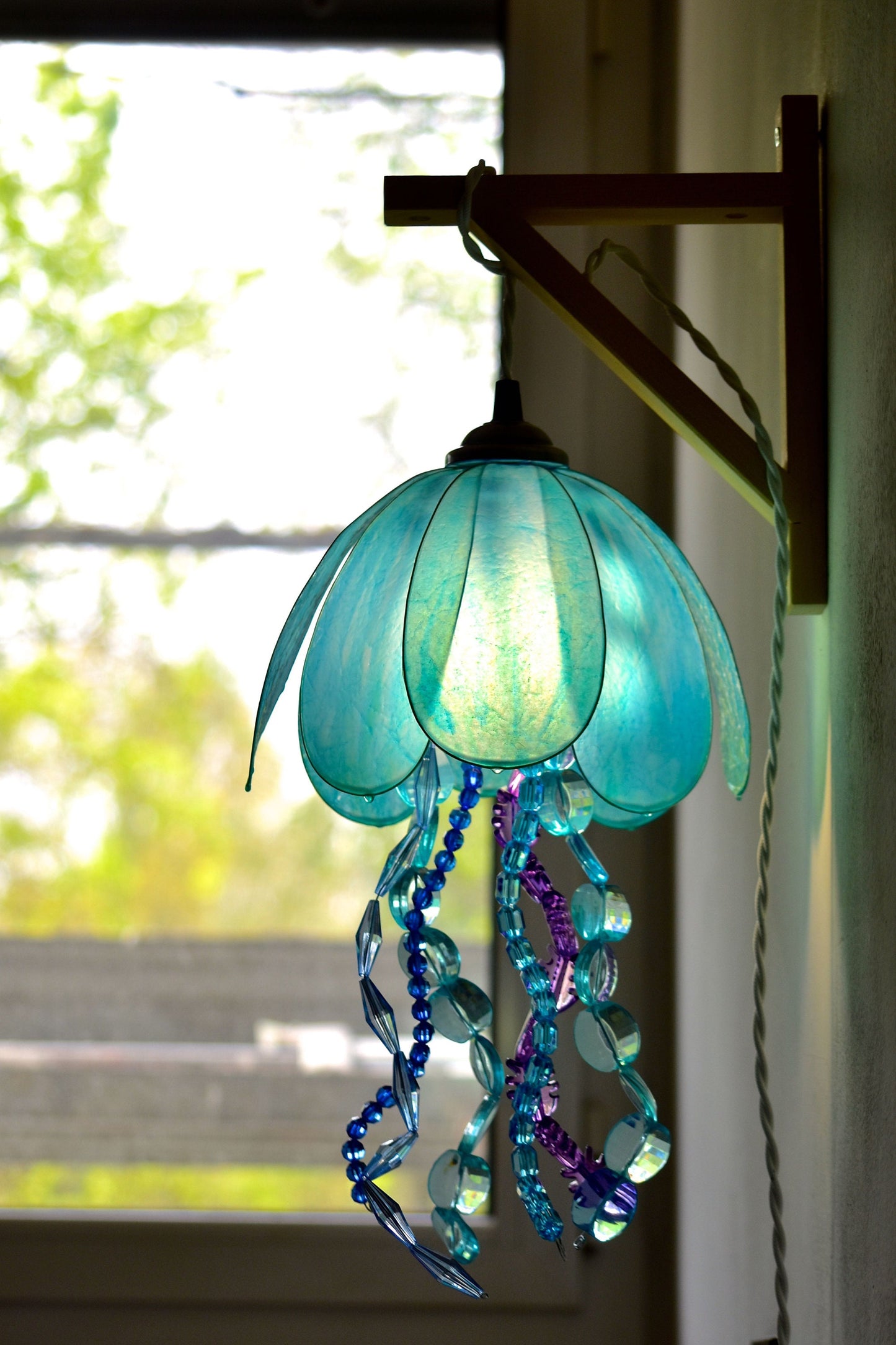 lampada a forma di medusa in resina da appendere alla parete, dipinta a mano