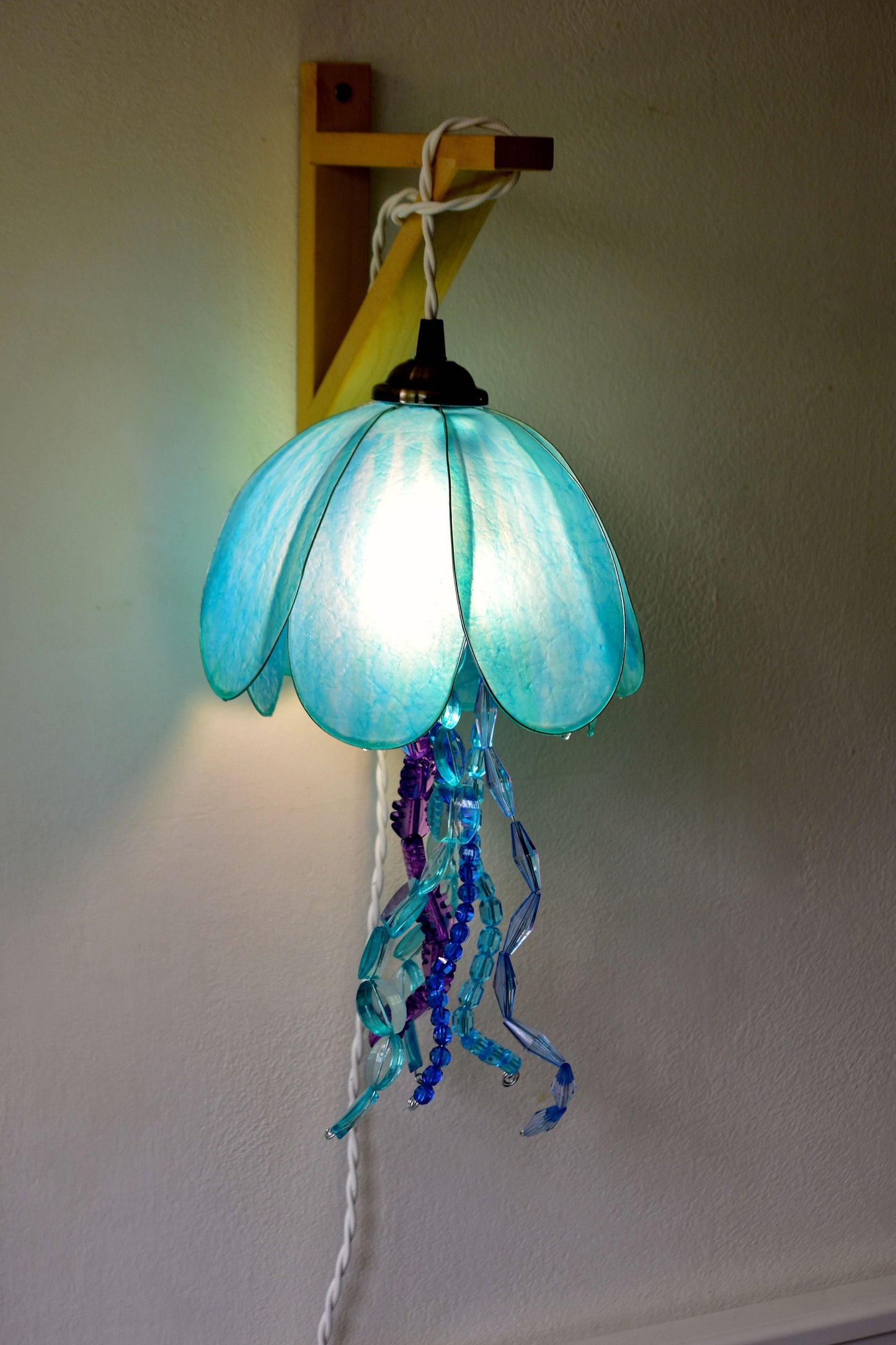 lampada a forma di medusa in resina da appendere alla parete, dipinta a mano