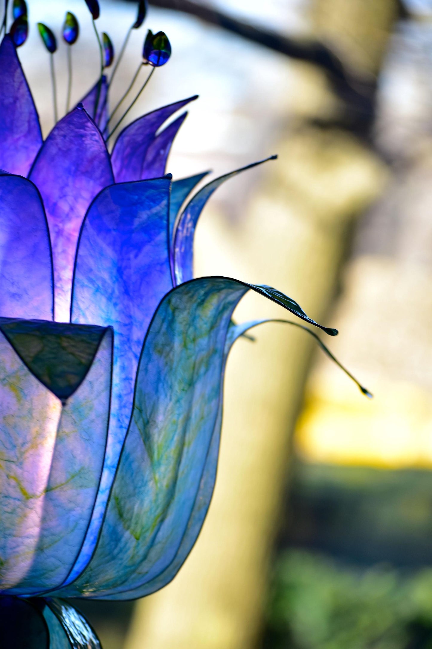 lampada da terra con paralume in resina ispirato alle piume di pavone blu e viola