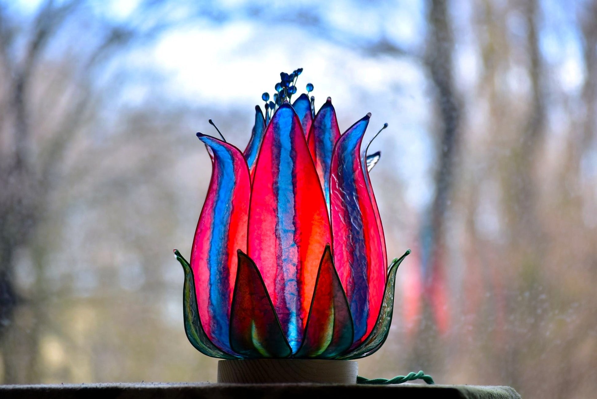 lampada tavolo rossa e blu a forma di fiore su sfondo naturale - Fiorediluce