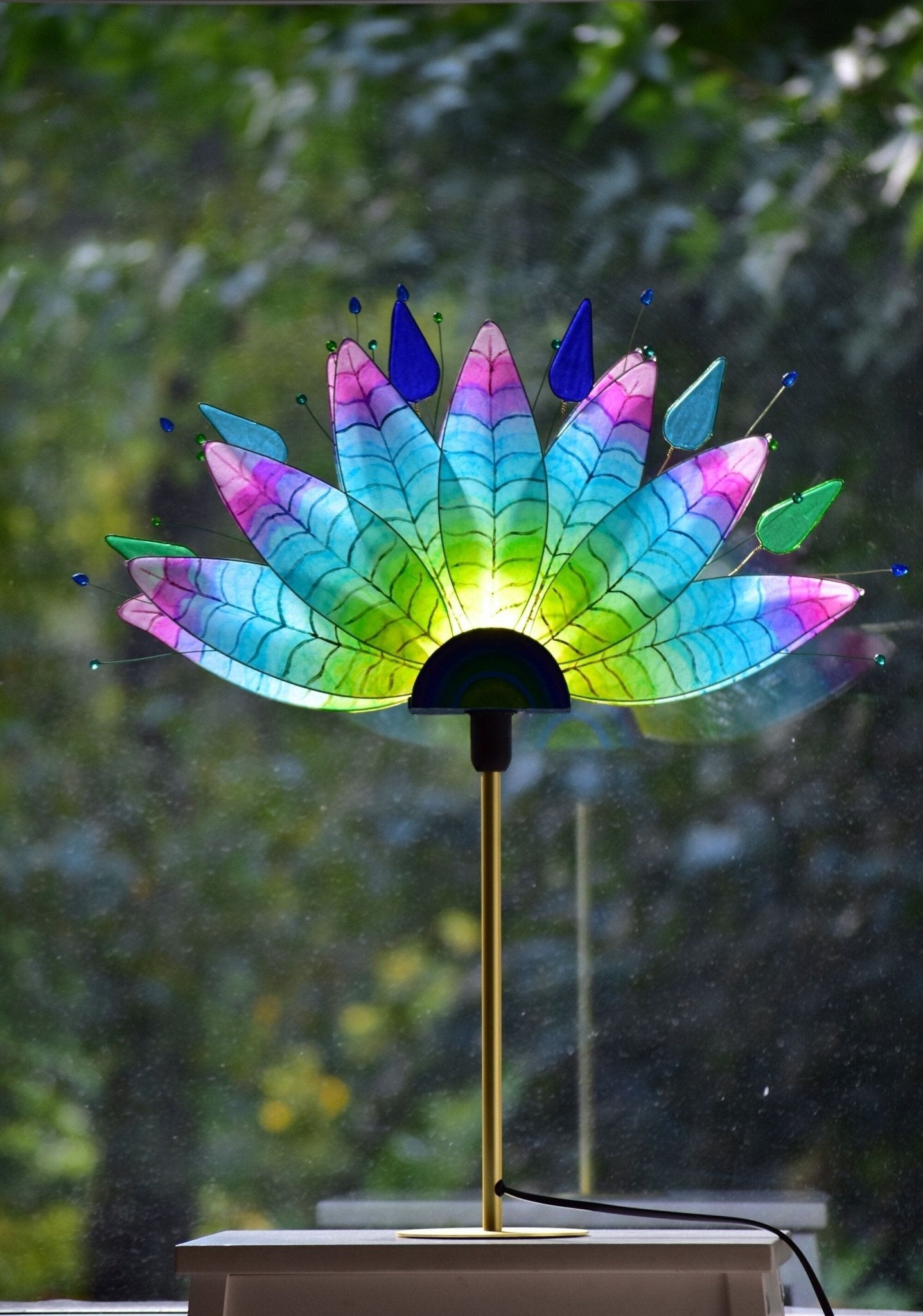 Lampada da tavolo fatta a mano con piume di pavone colorate su stelo dorato - Fiorediluce