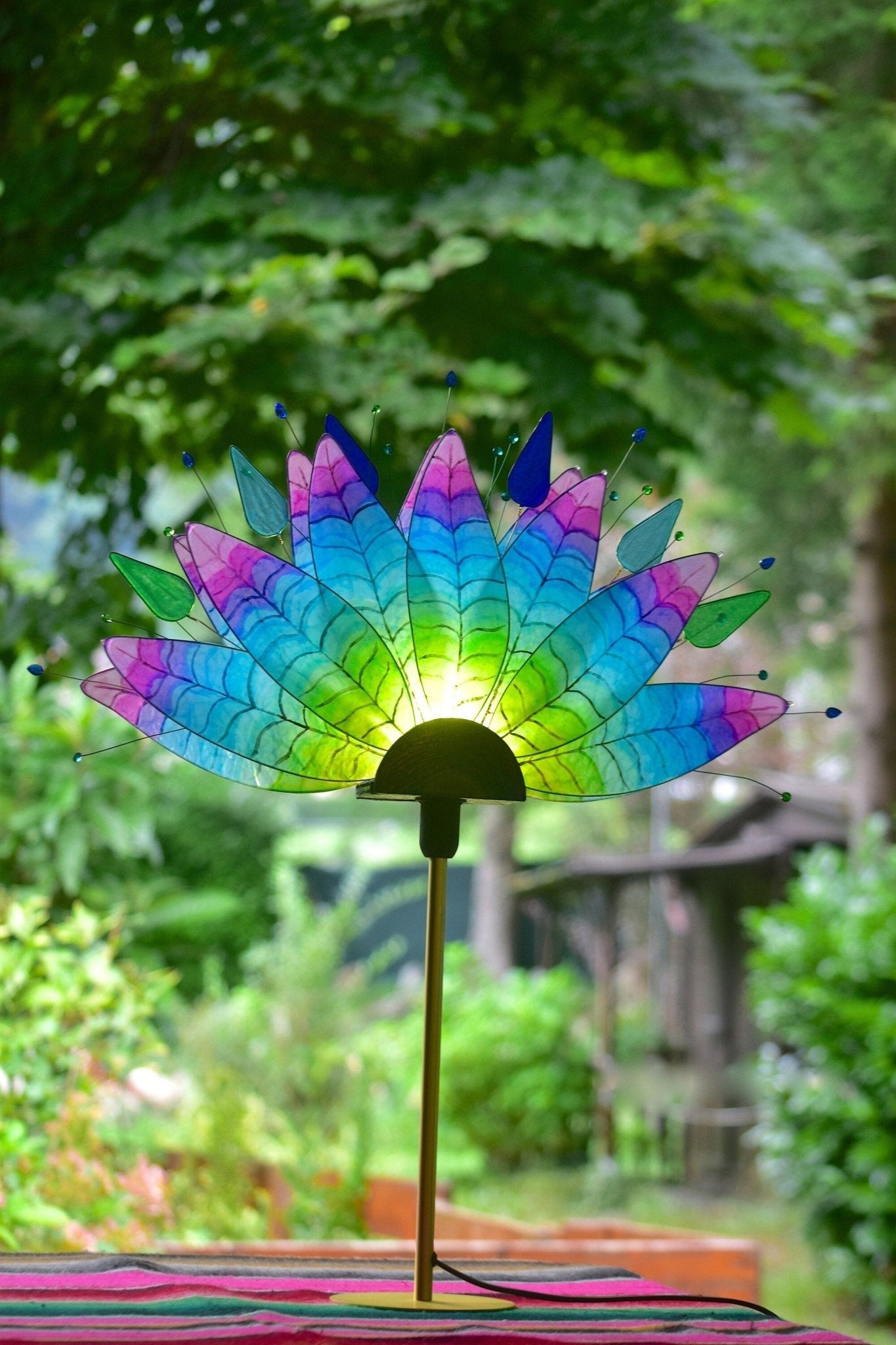 Lampada da tavolo fatta a mano con piume di pavone colorate su stelo dorato - Fiorediluce